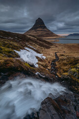 Dramatic coastal landscape of the Snaefellsnes peninsula. Rugged basalt cliffs, moss-covered lava fields, and mountains meeting the ocean in Iceland.