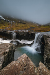 Fototapeta premium Beautiful Skutafoss waterfall flowing near Hofn. Scenic Icelandic nature with a stream falling over rocky terrain in the East Fjords.