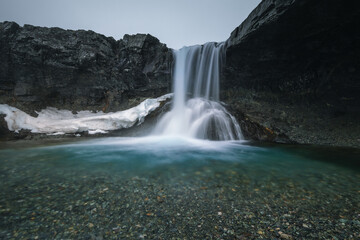 Obraz premium Beautiful Skutafoss waterfall flowing near Hofn. Scenic Icelandic nature with a stream falling over rocky terrain in the East Fjords.