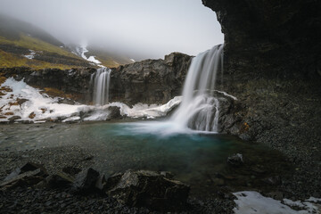Obraz premium Beautiful Skutafoss waterfall flowing near Hofn. Scenic Icelandic nature with a stream falling over rocky terrain in the East Fjords.