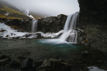 Obraz premium Beautiful Skutafoss waterfall flowing near Hofn. Scenic Icelandic nature with a stream falling over rocky terrain in the East Fjords.