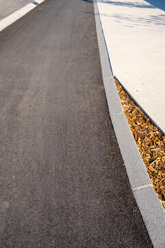 Road asphalt curb sidewalk empty travel lines and perspective on street in daylight with wide copy space for transport themes and minimal design