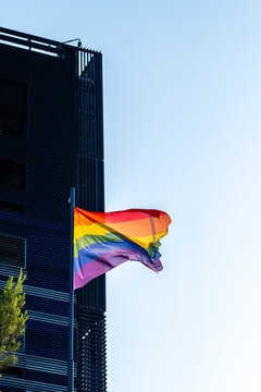 Rainbow flag pride lgbtq on building urban sky with waving modern facade in daylight expressing diversity inclusion and equality in the city