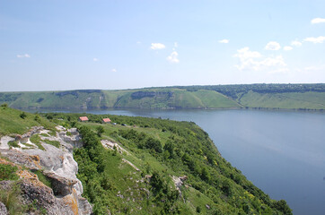 Obraz premium Scenic river valley with lush greenery and clear blue sky