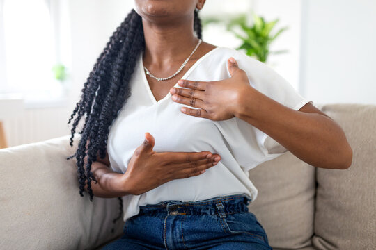 Close up of a Black woman performing a breast self-examination at home to check for lumps. Concept of breast cancer awareness, early detection, and proactive female healthcare.