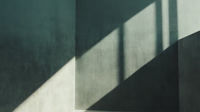 Sunrays strongly illuminate a minimalist concrete room, creating dramatic geometric patterns of light and shadow across the textured floor and walls, implying space, inspiration, and solitude