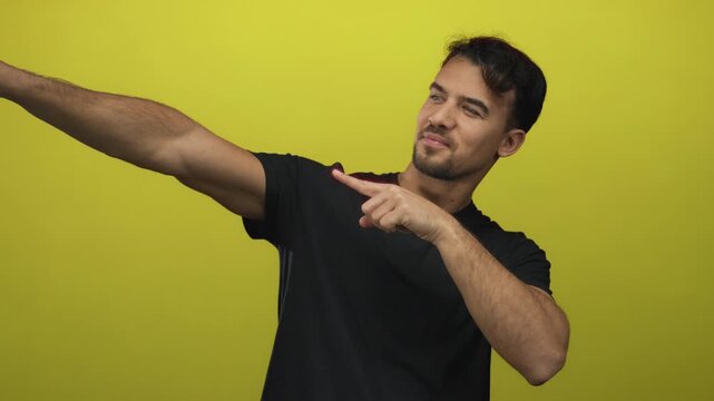 Young man confidently gesturing against a vibrant yellow background, showcasing a positive and dynamic attitude.