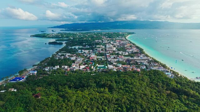 Drone moves slowly above Boracay coastline revealing turquoise sea and town