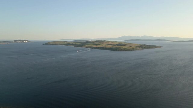 Aerial flytowards Great Cumbrae Island and Isle of Arran background