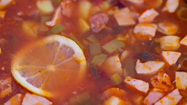 Hearty Russian stew, Traditional smoky soup with vegetables, Rich tomato broth with smoked meat and herbs, Steaming bowl of classic Russian solyanka with vegetables and spices