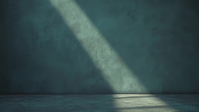 Empty concrete room featuring a stark blue green textured wall and floor, illuminated by a diagonal beam of natural light creating a strong contrast and sense of space