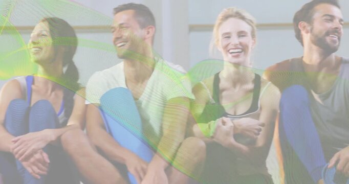 Fitness group holding foam rollers laughing for camaraderie while camera panning revealing joiners