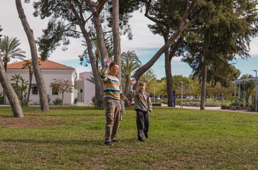 Father and daughter flying paper airplane in park, playful family and childhood