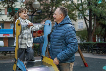 Father playing with nine year old daughter at playground, family bonding and happy childhood concept