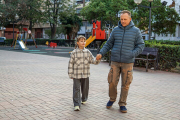Obraz premium Father playing with nine year old daughter at playground, family bonding and happy childhood concept
