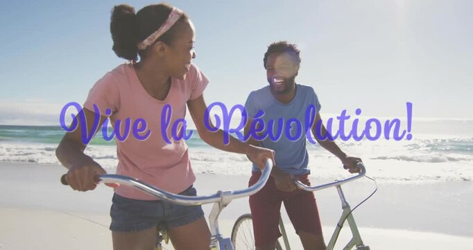 Riding bicycles on beach, two people smiling with Vive la R&eacute;volution! animation text
