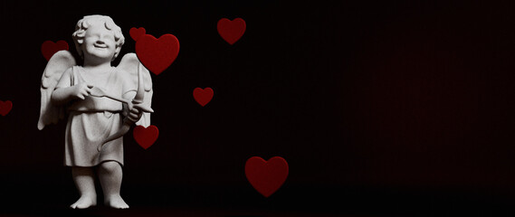 Fototapeta premium White Cupid Statue, Red Hearts for Valentine's Love Background