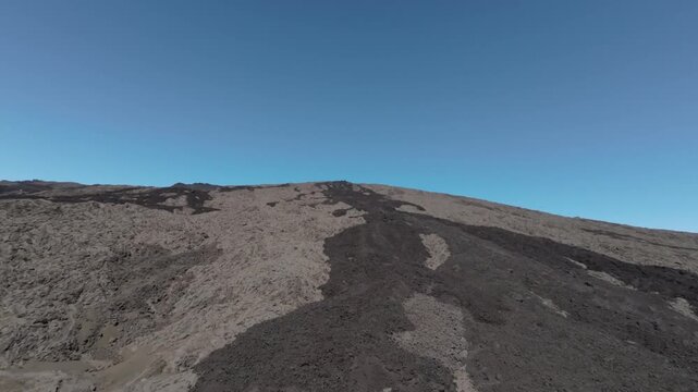 Aerial view of a vast expanse of dark, volcanic rocky terrain under a clear blue sky, Saint Benoit, Canton de Saint-Benoit-2, Reunion.