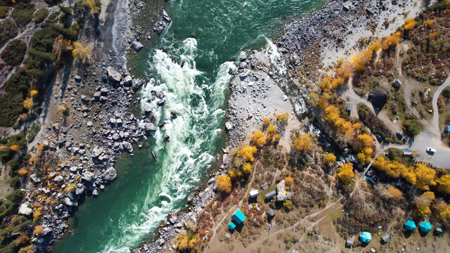 Aerial River Gorge With Research Camp, Small Tents Clustered On Rocky Flats, Measuring Instruments Near Shoreline, Swirling Emerald Current Cutting Through Gravel Bars, Scientific Fieldwork Atmosphere