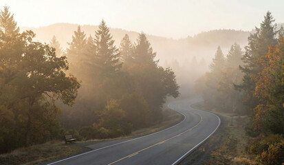 Fototapeta premium Mountain road in foggy landscape at sunset