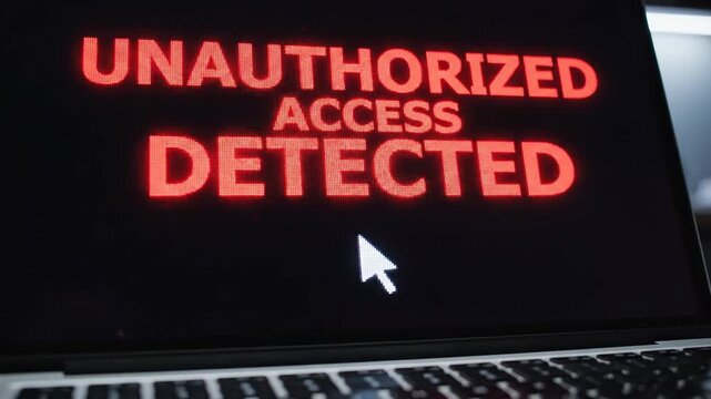 Laptop computer screen displays red unauthorised access detected message. Cybersecurity breach alert with cursor for data protection concept.