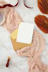 Romantic vertical invitation mockup with a blank card elegantly draped in soft fabric.