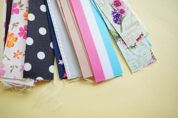 花柄やドット柄など、さまざまなデザインのリボンを並べた写真。ハンドメイドや手芸、ラッピング素材として使いやすい、カラフルで可愛らしいイメージ素材。