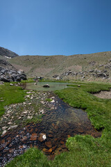 Waterfalls at the Sat Glacier Lakes. Lake landscapes in bloom in spring. Hakkari Cilo Sat Lakes. A lake view in the mountains. Hakkari Cilo Sat Glacier Lakes, mountains covered with flowers.Long expos