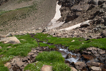 Waterfalls at the Sat Glacier Lakes. Lake landscapes in bloom in spring. Hakkari Cilo Sat Lakes. A lake view in the mountains. Hakkari Cilo Sat Glacier Lakes, mountains covered with flowers.Long expos