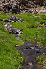 Waterfalls at the Sat Glacier Lakes. Lake landscapes in bloom in spring. Hakkari Cilo Sat Lakes. A lake view in the mountains. Hakkari Cilo Sat Glacier Lakes, mountains covered with flowers.Long expos