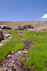 Waterfalls at the Sat Glacier Lakes. Lake landscapes in bloom in spring. Hakkari Cilo Sat Lakes. A lake view in the mountains. Hakkari Cilo Sat Glacier Lakes, mountains covered with flowers.Long expos
