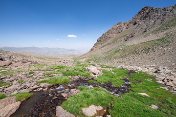 Waterfalls at the Sat Glacier Lakes. Lake landscapes in bloom in spring. Hakkari Cilo Sat Lakes. A lake view in the mountains. Hakkari Cilo Sat Glacier Lakes, mountains covered with flowers.Long expos
