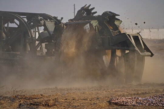 Military special equipment digs a trench in a field. Military exercises.