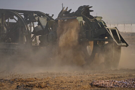 Military special equipment digs a trench in a field. Military exercises.