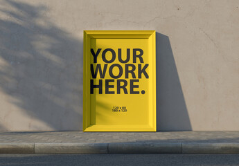 Vertical Framed poster Mockup next to concrete wall on the street