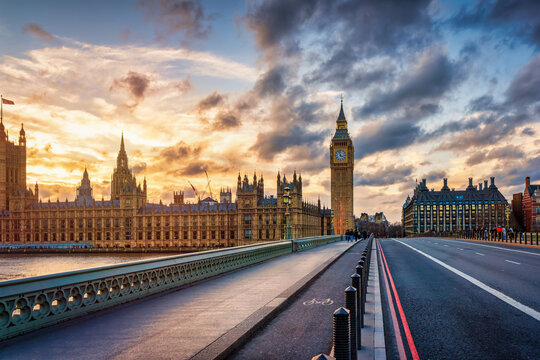View over the Westminster bridge towards Parliament building and Big Ben clock tower in London, England, during sunset time without people