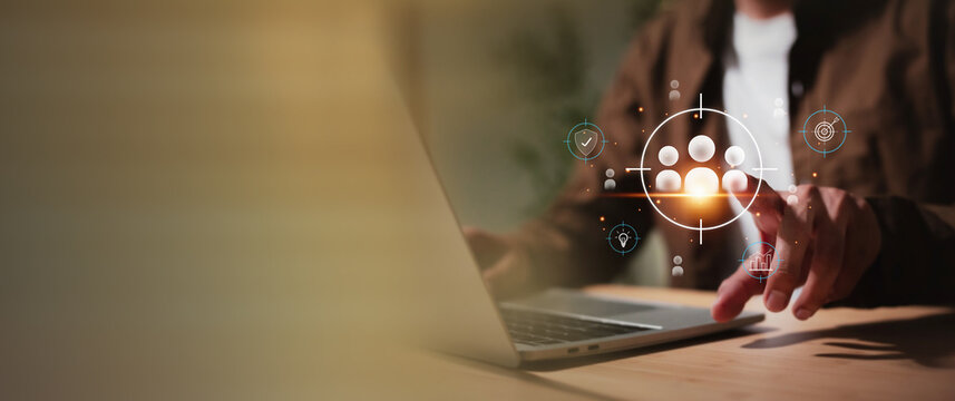 Businessman using a laptop to define a target audience or human resources, with floating icons representing security, idea, goal, and growth. Concept of digital marketing, HR management, data analytic