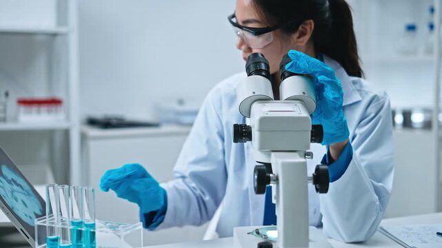 Scientist,Beautiful young woman scientist in laboratory working.female scientist doing some research.report and writing medical results,medicine documents in laboratory for healthcare,science review