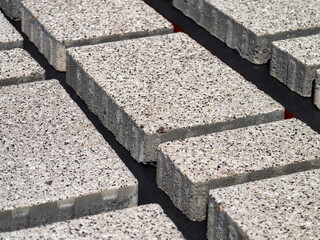 Light gray concrete blocks arranged on a surface for construction work at a building site during daylight hours