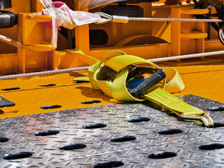 Yellow strap lies on work platform near industrial equipment in construction site during daylight hours