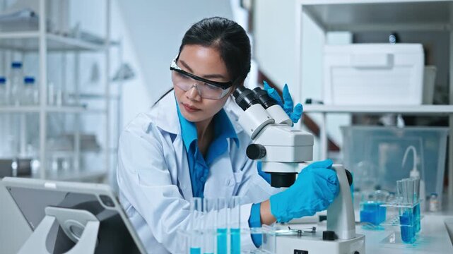 Scientist,Beautiful young woman scientist in laboratory working.female scientist doing some research.report and writing medical results,medicine documents in laboratory for healthcare,science review