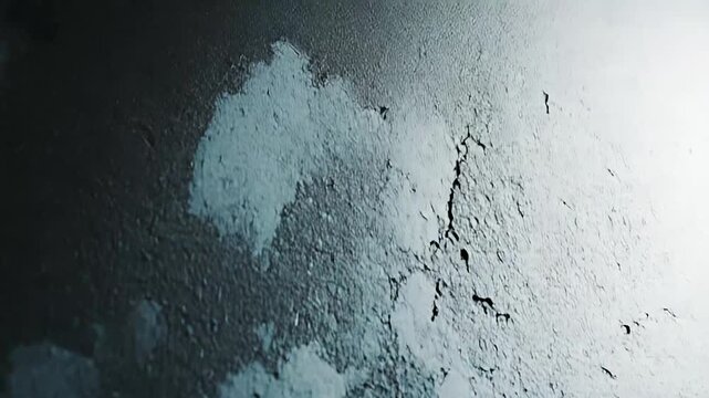 Dark gray grungy background with peeling paint, cracks and rough concrete texture creating a distressed, weathered industrial surface ideal for edgy, vintage backdrops and overlays