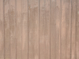 Fototapeta premium ​Weathered light brown wood background texture. Vertical wooden beadboard planks with distressed vintage finish. Rustic timber wall paneling surface for interior design or wallpaper