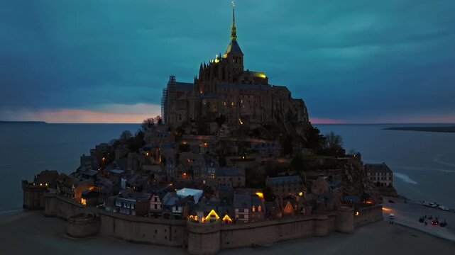 Aerial view of the famous historic Abbey Mont Saint Michel at night. Historic monastery with tidal flats. Normandy, France 