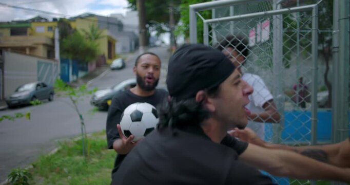 Group of Hispanic men outdoors intervening to stop a physical altercation, calming tension and separating friends in heated conflict, teamwork, emotion, and street realism