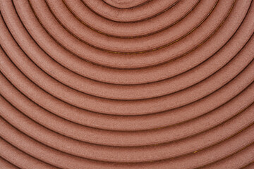Fototapeta premium A close up top view of a brown adhesive foam strip for window sealing arranged in a concentric circular pattern