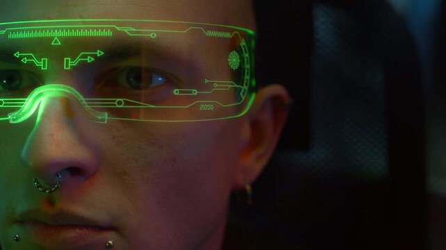 Big close up shot of face of Caucasian man with facial percing and smart LED visor getting scanned with red laser indoors