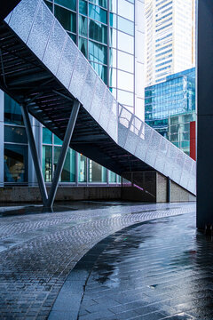 Modern Paris urban architecture with glass skyscraper bridge curve over wet pavement after rain in quiet corporate district cityscape