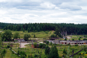 Countryside view with old structures and distant green forest