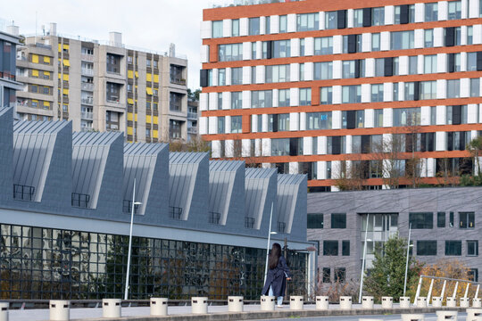 Modern residential architecture in Boulogne Billancourt Paris France on a rooftop urban walkway with a person backview crossing the terrace
